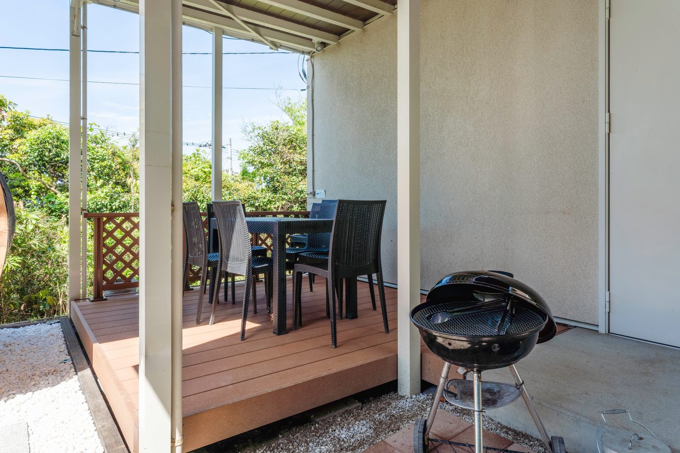 屋根と照明のあるデッキのBBQスペース